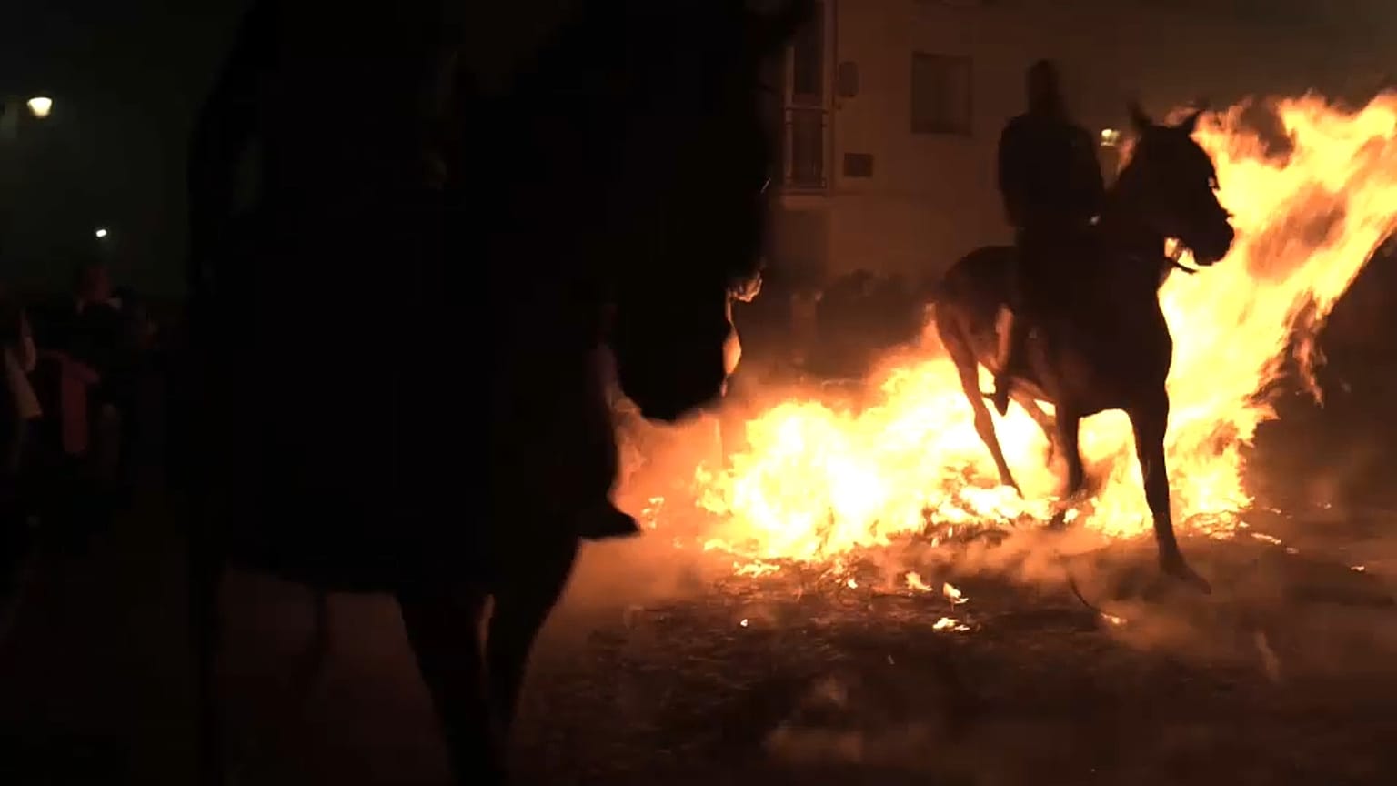 Un caballo pasa sobre una hoguera durante la celebración de Las Luminarias, en San Bartolomé de Pinares, Ávila, España.