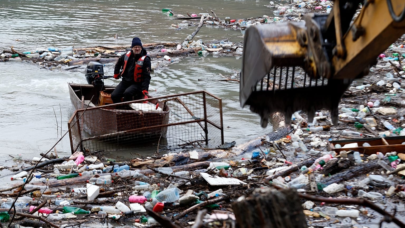 A crane clears garbage stuck at the Potpecko accumulation lake near Priboj, in southwest Serbia, Jan. 12, 2023. 
