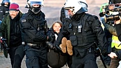 Polizeibeamte tragen Greta Thunberg während einer Protestaktion gegen Kohleabbau bei Lützerath weg