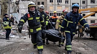 Mentők hoznak ki egy áldozatot a lakóházból