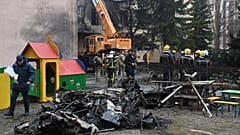 Des pompiers travaillent près du site où un hélicoptère s'est écrasé près d'une école à Brovary, tuant 18 personnes, dont 3 enfants