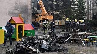Des pompiers travaillent près du site où un hélicoptère s'est écrasé près d'une école à Brovary, tuant 18 personnes, dont 3 enfants
