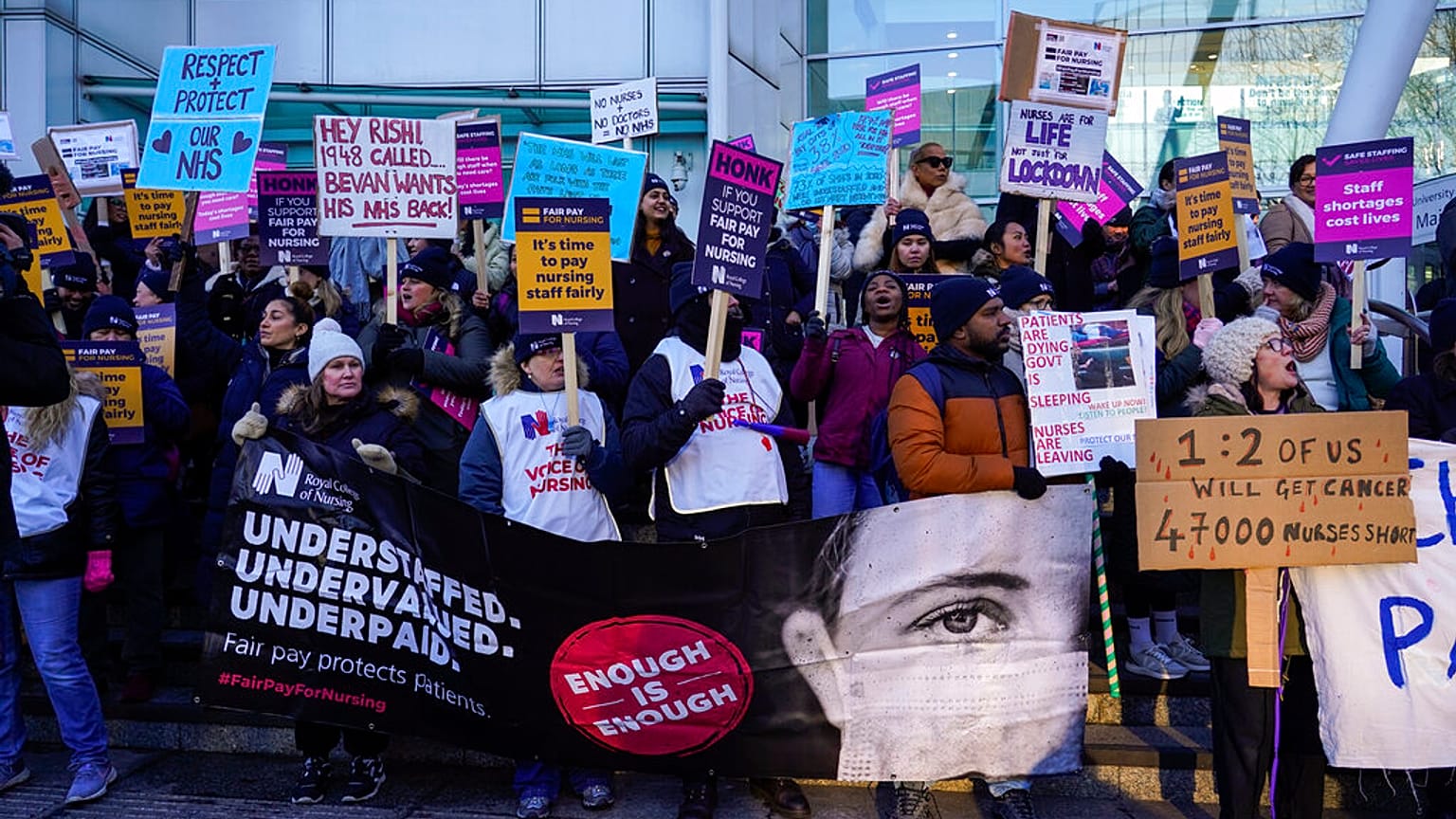 Nurses hold banners and placards as they picket during a strike over pay, outside the University College Hospital, in London