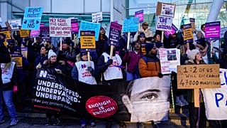 Nurses hold banners and placards as they picket during a strike over pay, outside the University College Hospital, in London