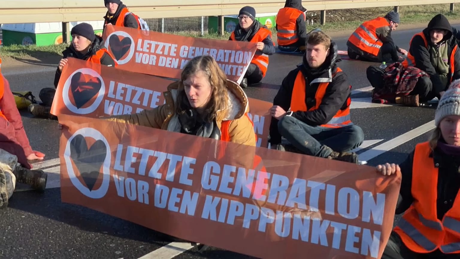 Aktivist:innen kleben auf einer Zufahrtsstraße