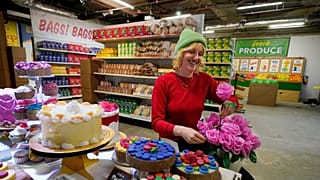 Robin Frohardt, creator of the Plastic Bag Store, holds plastic bag roses at the art installation, Tuesday, Jan. 17, 2023 in Ann Arbor, Mich.