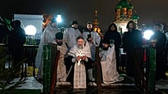 Ein russisch-orthodoxer Priester segnet das eiskalte Wasser während Epiphanias nahe der Dreifaltigkeitskirche in Moskau, 19.1.2023