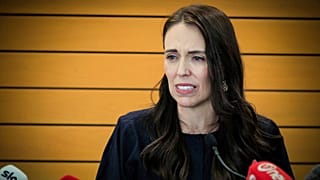 New Zealand Prime Minister Jacinda Ardern grimaces as she announces her resignation at a press conference in Napier, New Zealand.