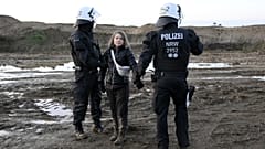 Rendőrök viszik el a svéd klímaaktivistát a lützerathi lignitbánya területéről