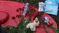 Flowers and toys are placed on a fragment of a helicopter that crashed at a kindergarten in Brovary, in the outskirts of Kyiv, Ukraine