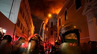 Polizisten blockieren eine Straße, nachdem es in Lima zu Zusammenstößen mit Regierungsgegnern gekommen ist