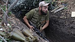 Um soldado ucraniano caminha ao longo de uma trincheira na região de Donetsk, na Ucrânia, a 15 de Agosto de 2022.