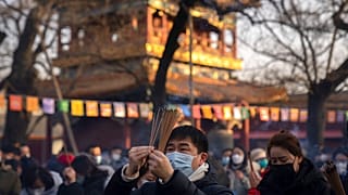 Visitors burn incense as they pray on the first day of the Lunar New Year holiday at the Lama Temple in Beijing, Sunday, Jan. 22, 2023.