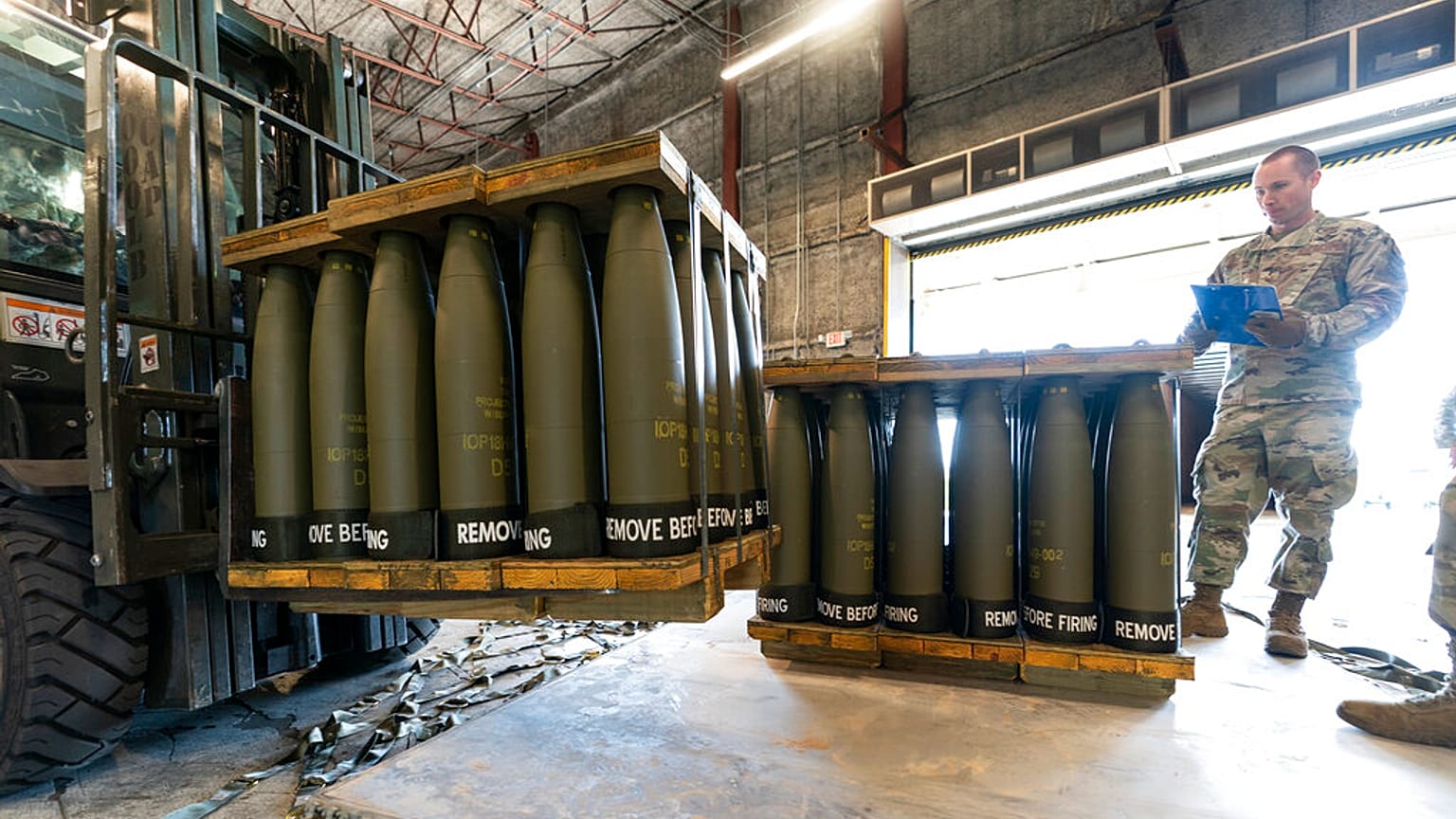 US Air Force Staff Sgt. Cody Brown, right, with the 436th Aerial Port Squadron, checks pallets of 155 mm shells ultimately bound for Ukraine, April 29, 2022.