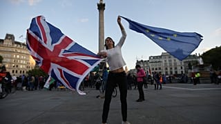 A Pro-European Union protester holds Union and European flags in Trafalgar square during a rally in central London on September 13, 2017