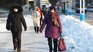 Phenjani lakosok sétálnak a hóban december 23-án