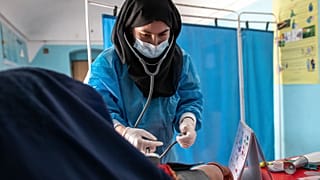 معاینه یک زن حامله افغان توسط کارمند زن یک نهاد غیردولتی بخش بهداشت و درمان