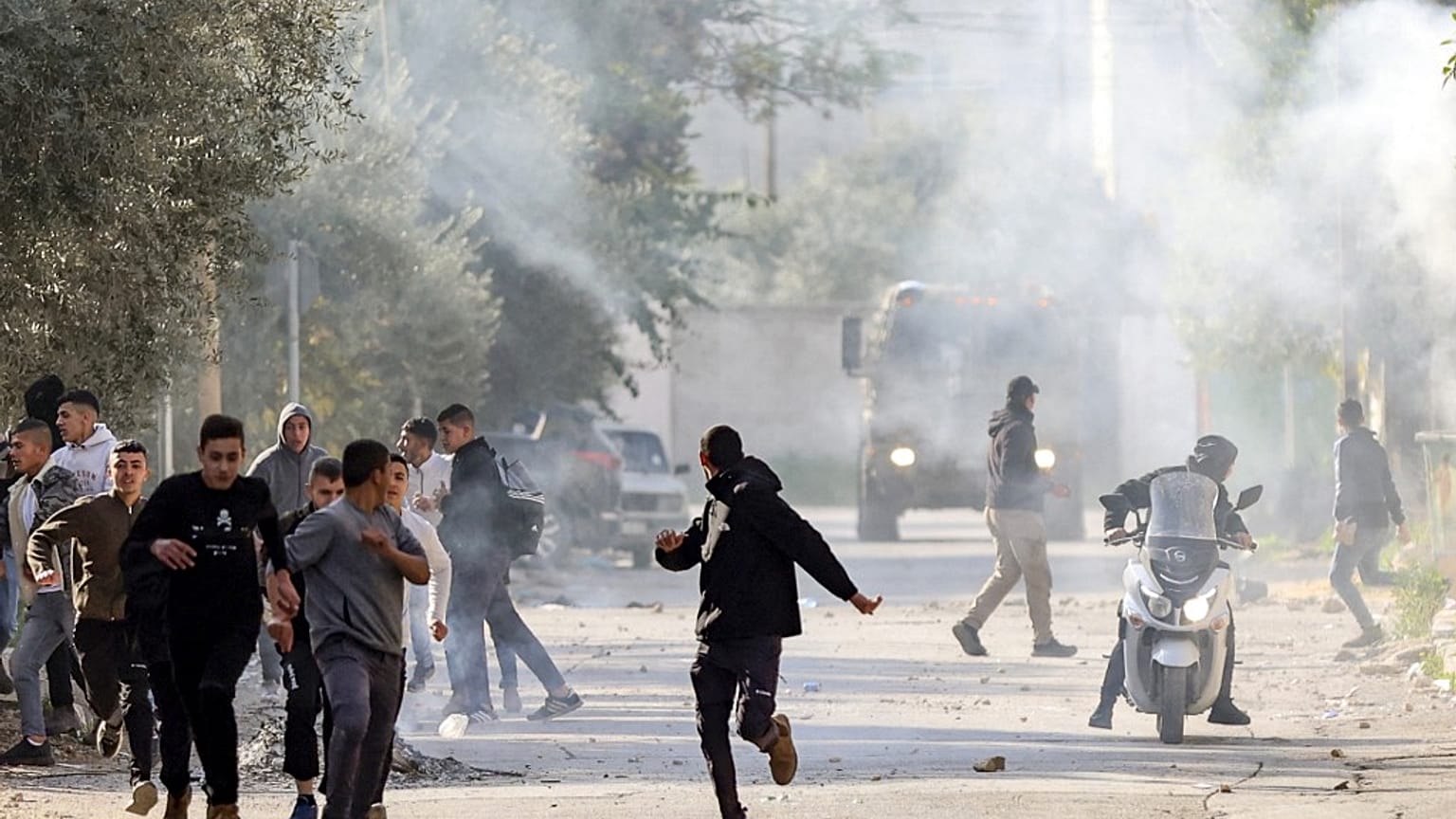Des Palestiniens courent pour s'abriter lors d'affrontements avec les forces israéliennes dans la ville de Jénine, en Cisjordanie occupée, le 26 janvier 2023.
