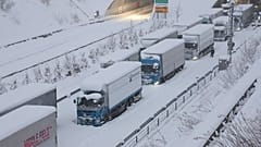 Des camions sont vus coincés en raison de la neige abondante sur la voie rapide Shin-Meishin à Yokkaichi, dans la préfecture de Mie, le 25 janvier 2023.