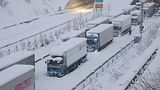 Des camions sont vus coincés en raison de la neige abondante sur la voie rapide Shin-Meishin à Yokkaichi, dans la préfecture de Mie, le 25 janvier 2023.