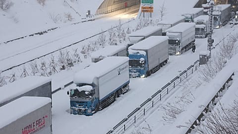 Des camions sont vus coincés en raison de la neige abondante sur la voie rapide Shin-Meishin à Yokkaichi, dans la préfecture de Mie, le 25 janvier 2023.