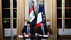 الرئيس الفرنسي إيمانويل ماكرون (يمين) ورئيس الوزراء العراقي محمد شياع السوداني يوقعان اتفاقية في باريس 