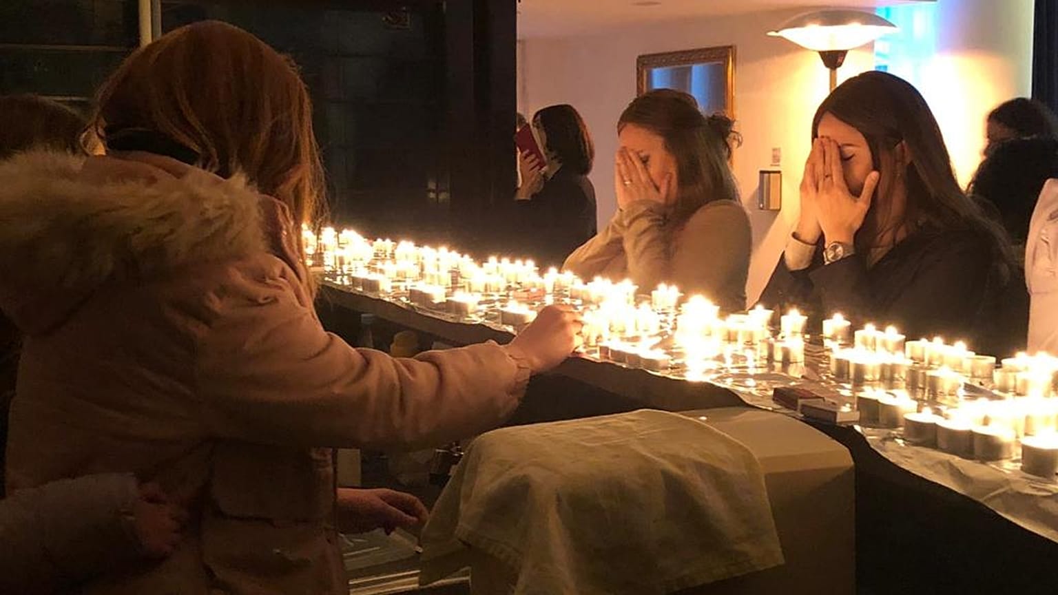 Jewish women gather to pray around candles.