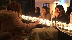 Jewish women gather to pray around candles.