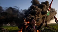 فلسطينيون يحرقون الإطارات ويلوحون بالعلم الوطني خلال احتجاج على الغارة العسكرية الإسرائيلية في مدينة جنين بالضفة الغربية. الأربعاء 26 يماير/كانون الثاني 2023