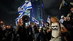 Israelíes corean eslóganes y ondean la bandera nacional durante una protesta contra la reforma de Netanyahu en Tel Aviv, Israel, el 28 de enero de 2023.