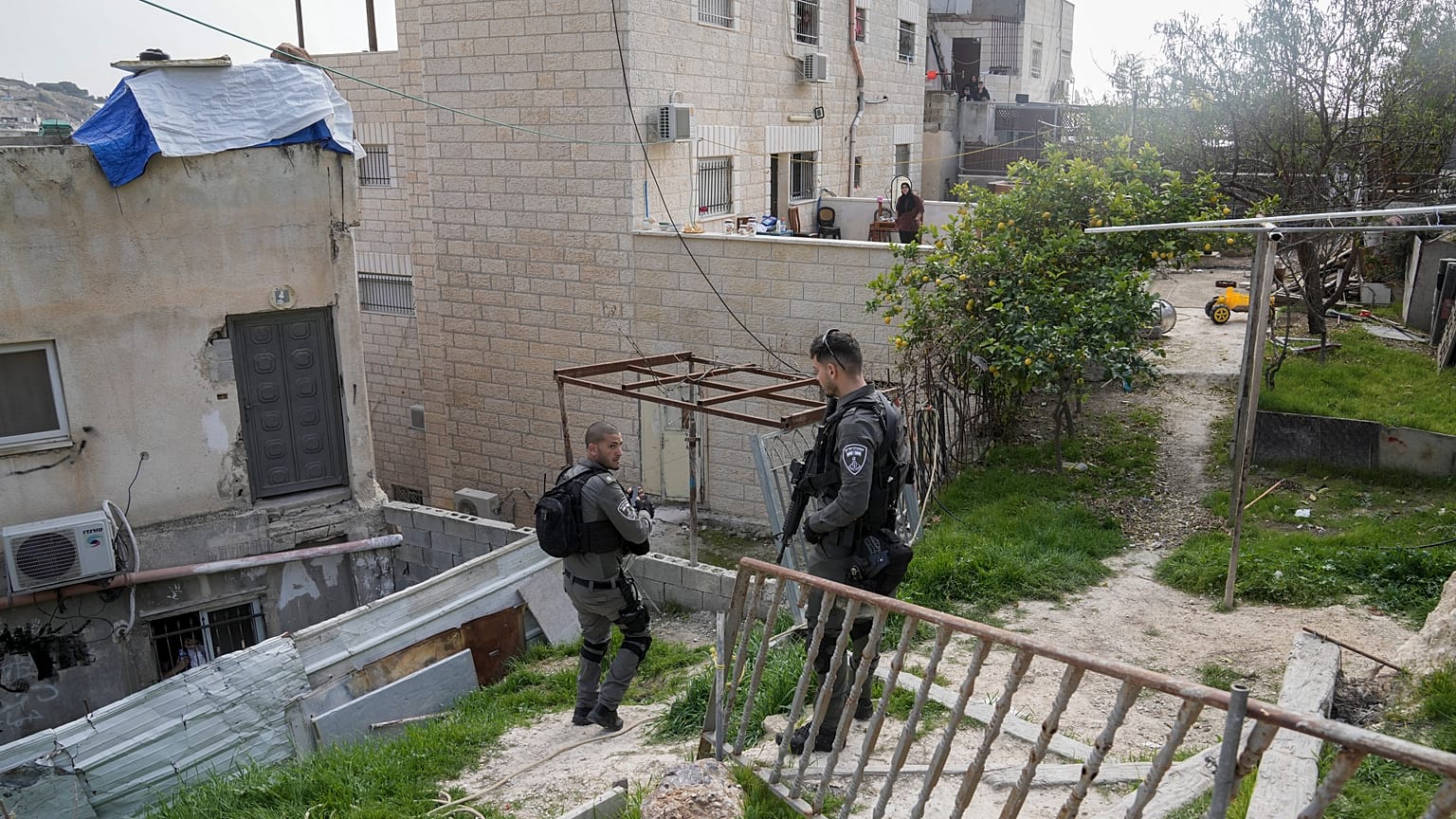 Israeli paramilitary border police stand next to the family home of a Palestinian gunman who killed several people.