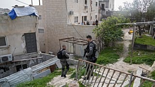 Israeli paramilitary border police stand next to the family home of a Palestinian gunman who killed several people.