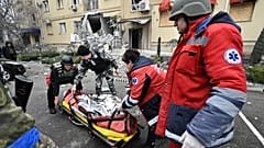 Ukrainian medics carry the body of a local resident killed in a residential building after a Russian shelling in Kherson, southern Ukraine, on January 29, 2023.