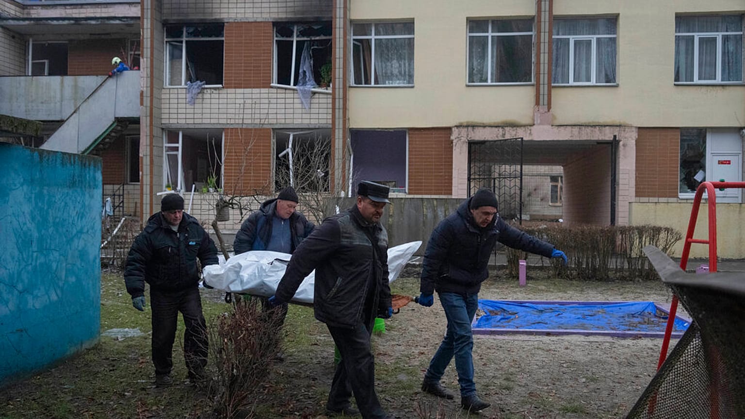 Des employés municipaux transportent des corps de victimes d'un accident d'hélicoptère depuis un jardin d'enfants à Brovary, près de Kyiv