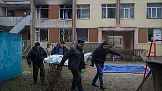 Des employés municipaux transportent des corps de victimes d'un accident d'hélicoptère depuis un jardin d'enfants à Brovary, près de Kyiv