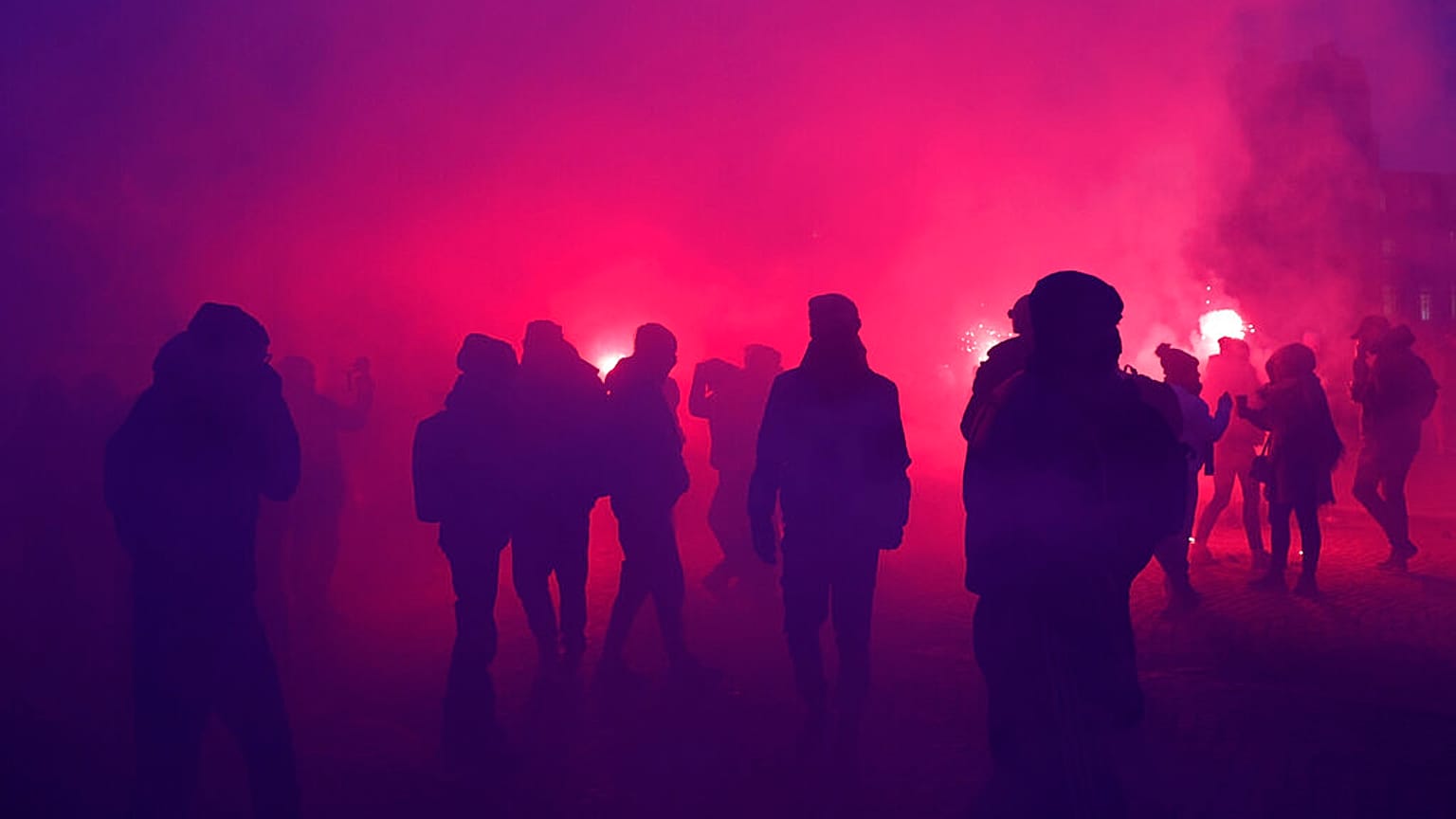 Demonstrators walk through flare smoke during a demonstration against plans to push back France's retirement age,Jan. 31, 2023 in Paris. 