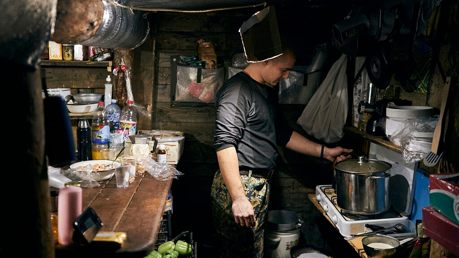 Ein ukrainischer Soldat kocht in einem Luftschutzkeller in Bachmut