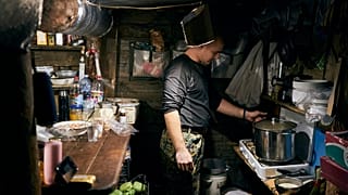 Ein ukrainischer Soldat kocht in einem Luftschutzkeller in Bachmut