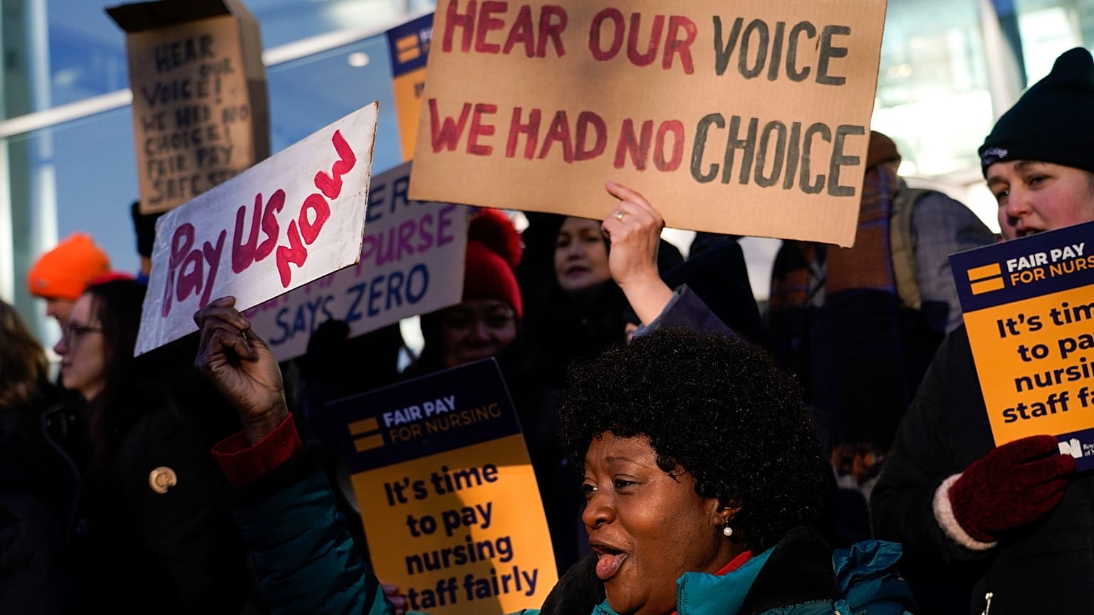 FILE: Nurses hold banners and placards as they picket during a strike over pay, outside the University College Hospital, in London, Wednesday, Jan. 18, 2023.