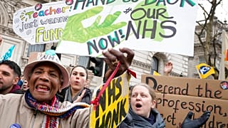 Des manifestants agitent des banderoles alors qu'ils se tiennent à Westminster à Londres, le mercredi 1er février 2023