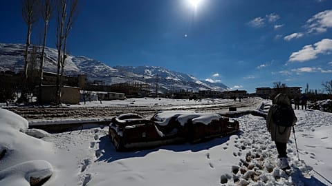 FILE - People walk in the snow in countryside near Damascus, Syria, Friday, Jan. 21, 2022