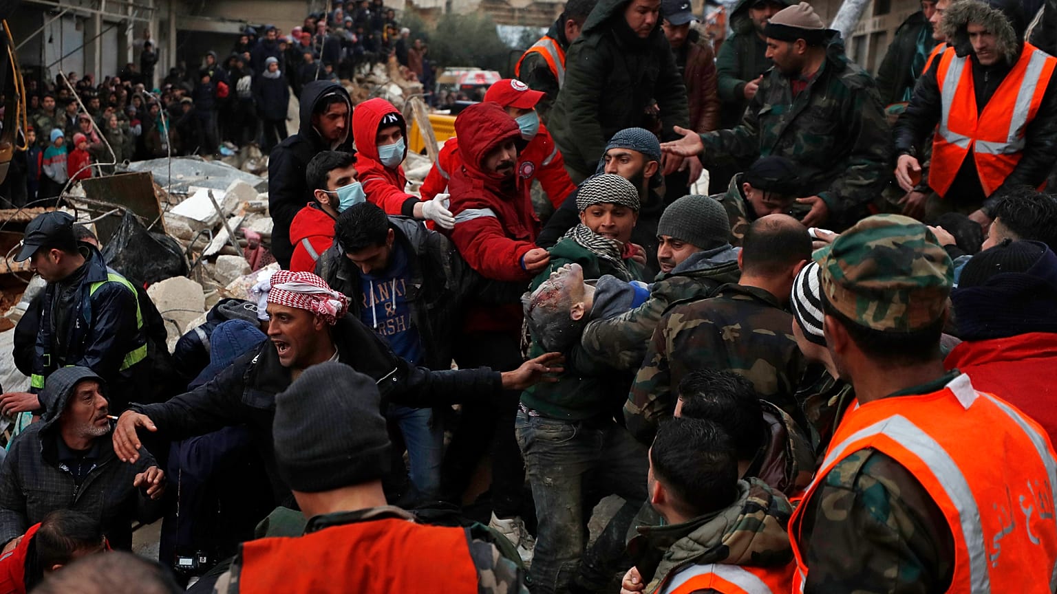 Des secouristes portent une victime du tremblement de terre alors qu'ils fouillent les décombres des bâtiments effondrés à Hama, Syrie, le 6 février 2023.