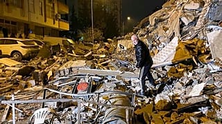 رجل بين المباني المنهارة في ديار بكر، جنوب تركيا، في وقت مبكر من يوم الاثنين، 6 فبراير 2023