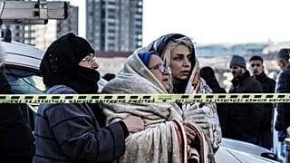 Выжившие следят за спасательными работами в турецком городе Газиантеп