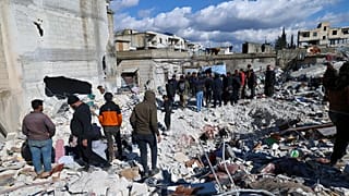 People search through the rubble of collapsed buildings where a newborn girl was found in the town of Jinderis, Aleppo province, Syria, 7 February 2023