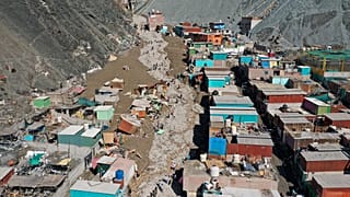 سكان يسيرون في شارع مليء بالحطام الناجم عن انهيار أرضي، في كامانا، بيرو، الثلاثاء 7 فبراير/شباط 2023.