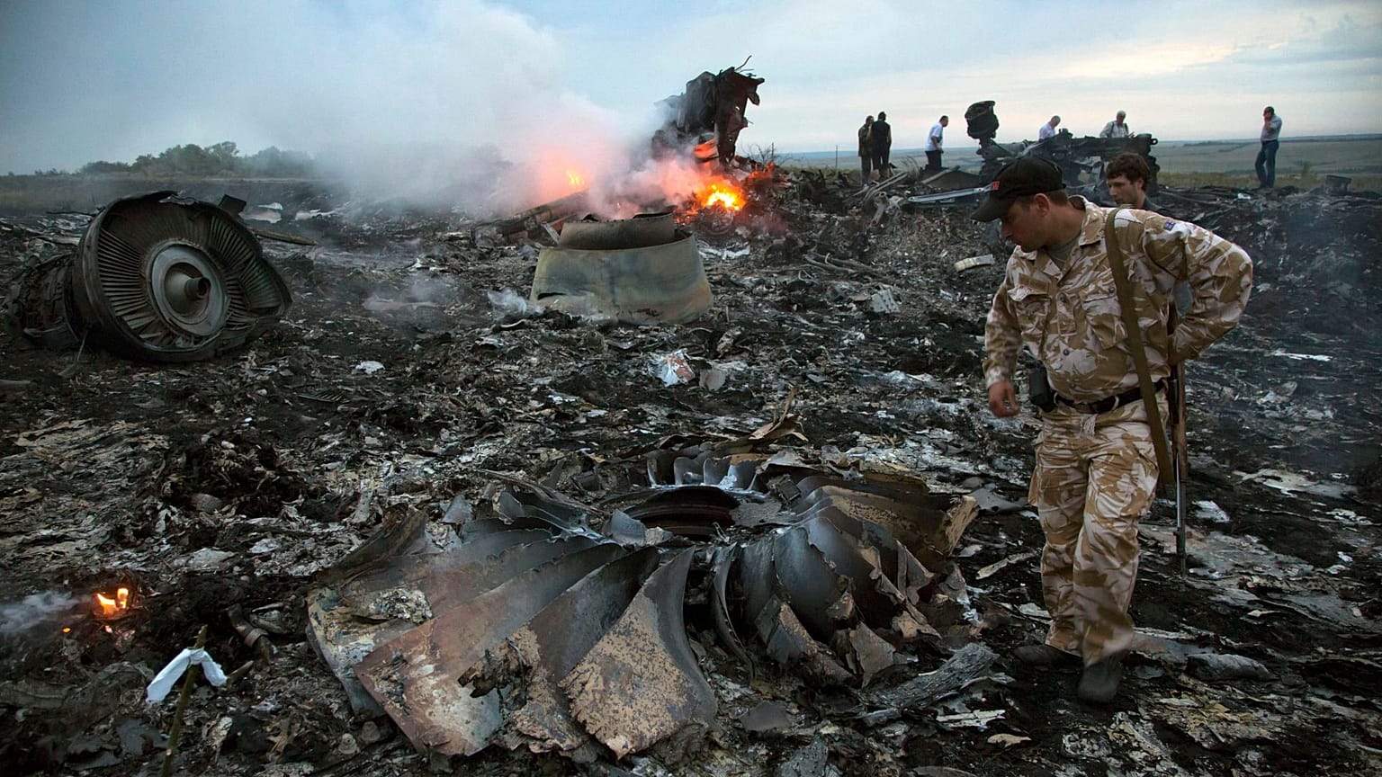 People walk amongst the debris at the crash site of a passenger plane near the village of Grabovo, Ukraine, July 17, 2014.
