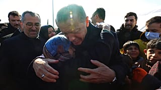 Turkey's President Recep Tayyip Erdogan and a survivor hug each other as he visits the Kahramanmaras city center destroyed by Monday's earthquakes
