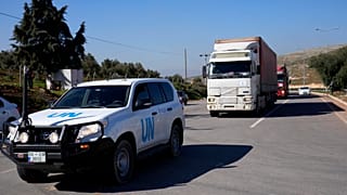 Грузовики с гуманитарной помощью едут в Сирию из Турции в сопровождении машины ООН. 