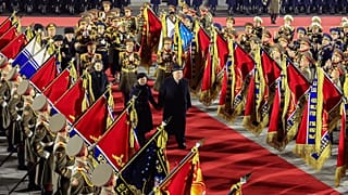 North Korean leader Kim Jong Un, center right, reviews an honor guard with his daughter, center left, and his wife Ri Sol Ju during a military parade